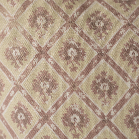 Beige and mauve textile with geometric diamond pattern containing floral motifs in a woven weave.