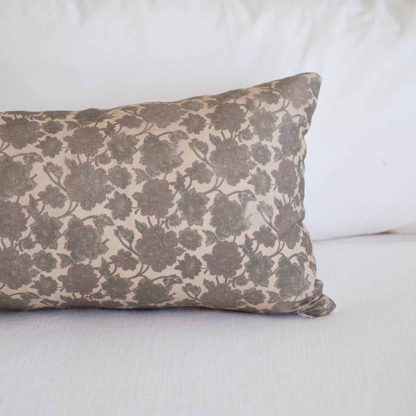 Rectangular lumbar pillow with taupe and cream damask floral pattern on white background.