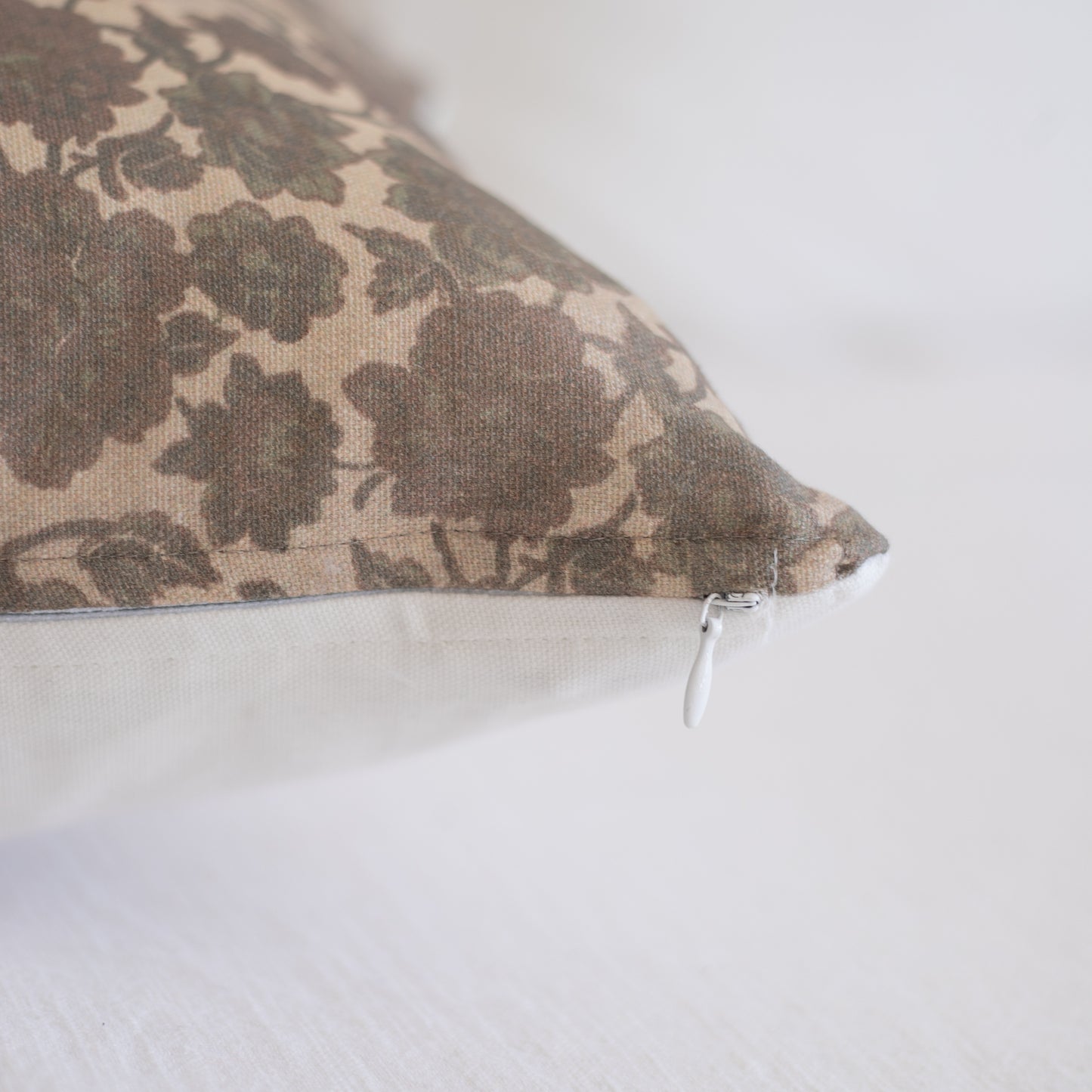 Nora lumbar pillow with taupe floral damask pattern and white zipper closure.