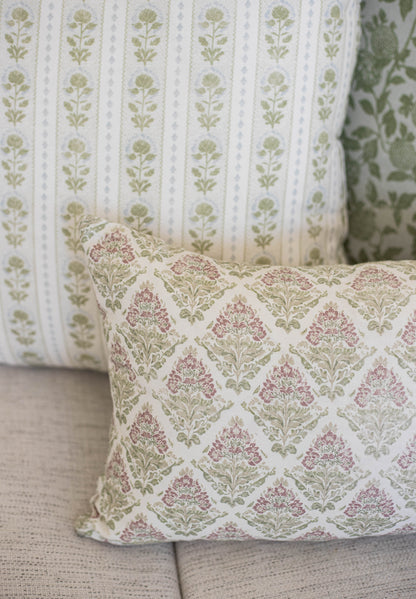 Five decorative pillows with floral damask and botanical stripe patterns in cream, mauve, and sage green.