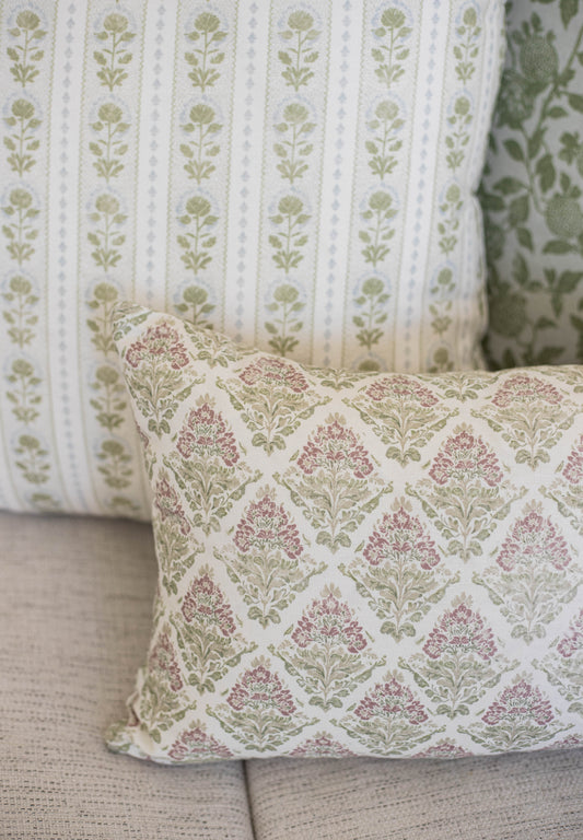 Five decorative pillows with floral damask and botanical stripe patterns in cream, mauve, and sage green.