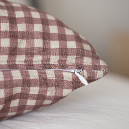 Rose and cream gingham patterned pillow with white zipper closure.