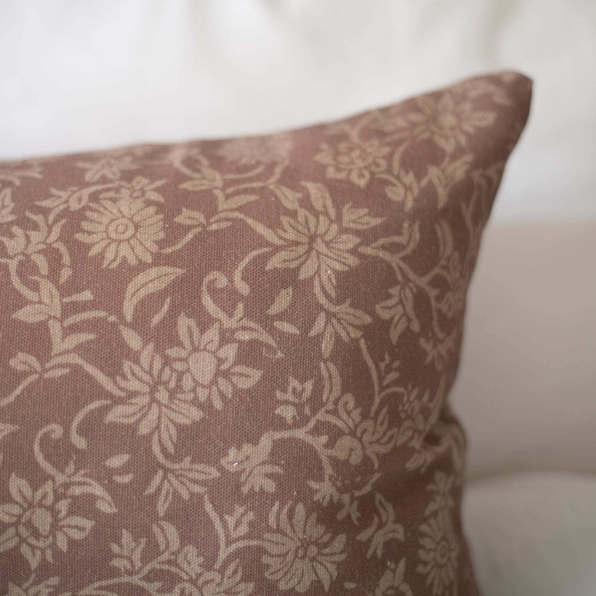 Taupe linen pillow with cream floral damask pattern.