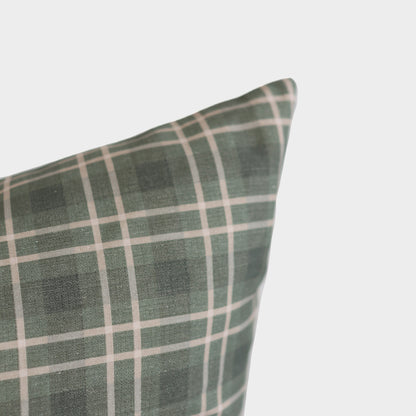 Green and white plaid pillow with grid pattern displayed at an angle against a light background.