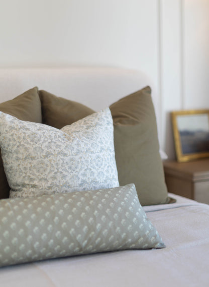 Three king pillow covers in neutral tones: one with damask pattern, one solid sage green, and one with white dot pattern on s