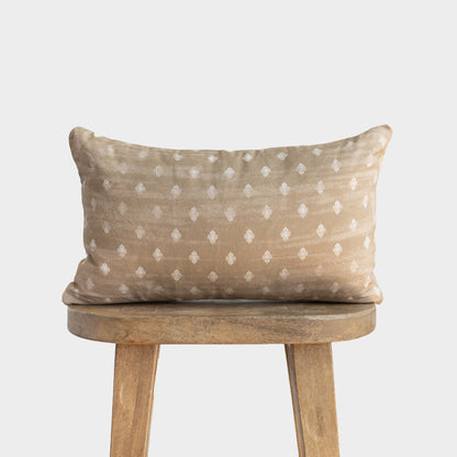 Beige cushion with white diamond pattern on wooden stool with curved back.