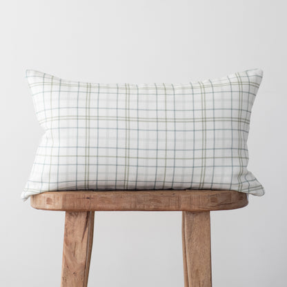 Rectangular linen pillow with gray and white plaid pattern displayed on wooden stool.