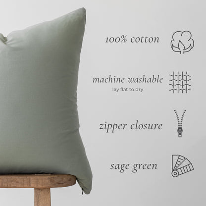 Sage green cotton pillow with zipper closure and care information icons.