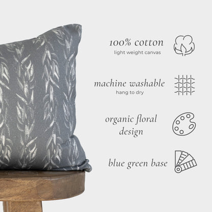 Sage green lumbar pillow with cream leaf pattern on wooden stool, displayed with product specifications.