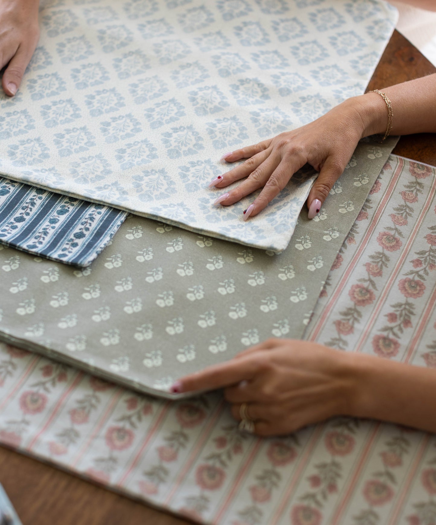 Three fabric swatches with floral and geometric patterns in blue, navy, and pink tones displayed flat.