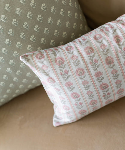 Rectangular pillow with pink floral stripe pattern and white piping, displayed next to a green pillow with small repeating mo