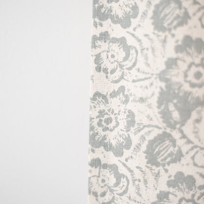 Cream curtain panel with gray floral and damask pattern in woven fabric texture.