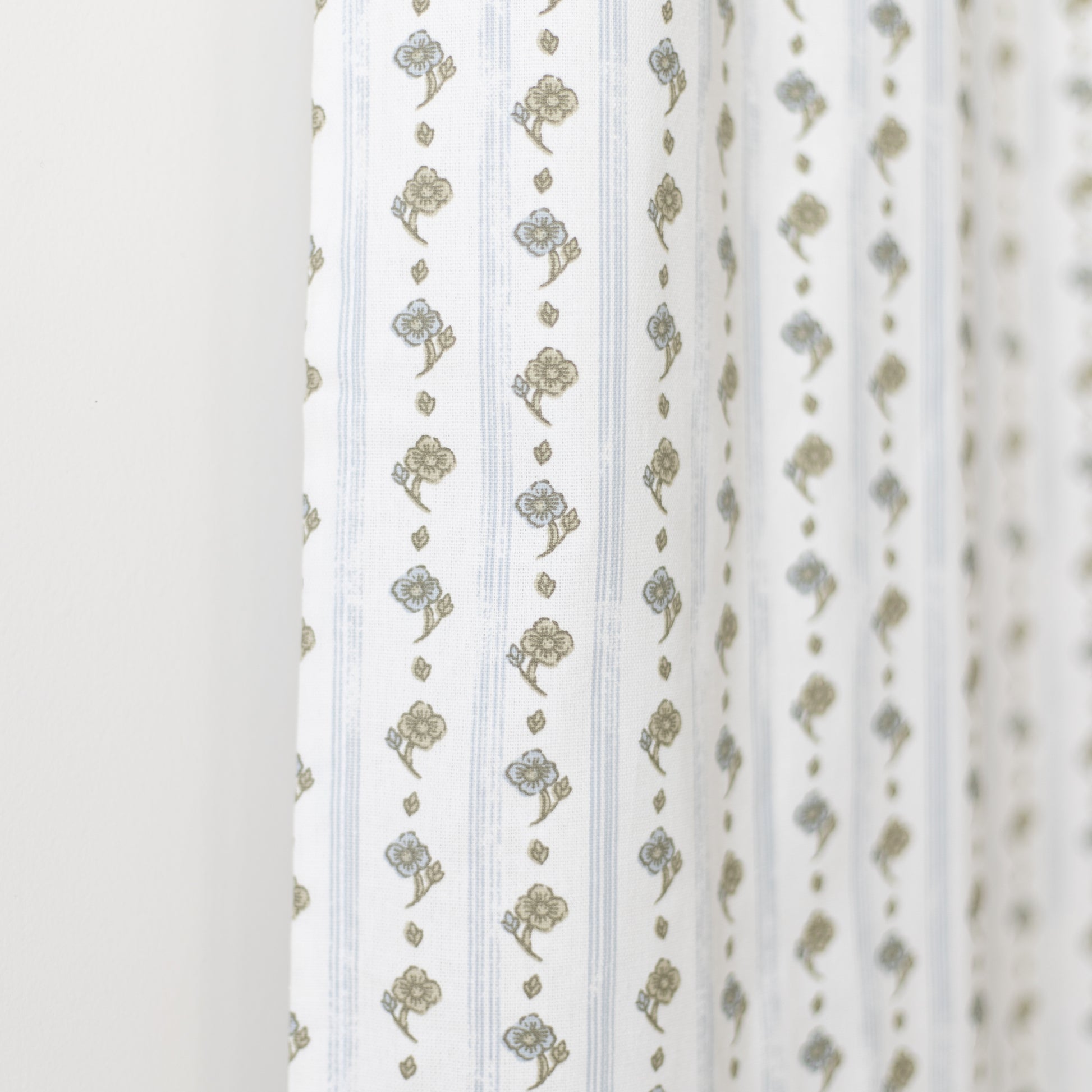 White curtain panel with vertical stripes and gold floral bouquet pattern throughout.