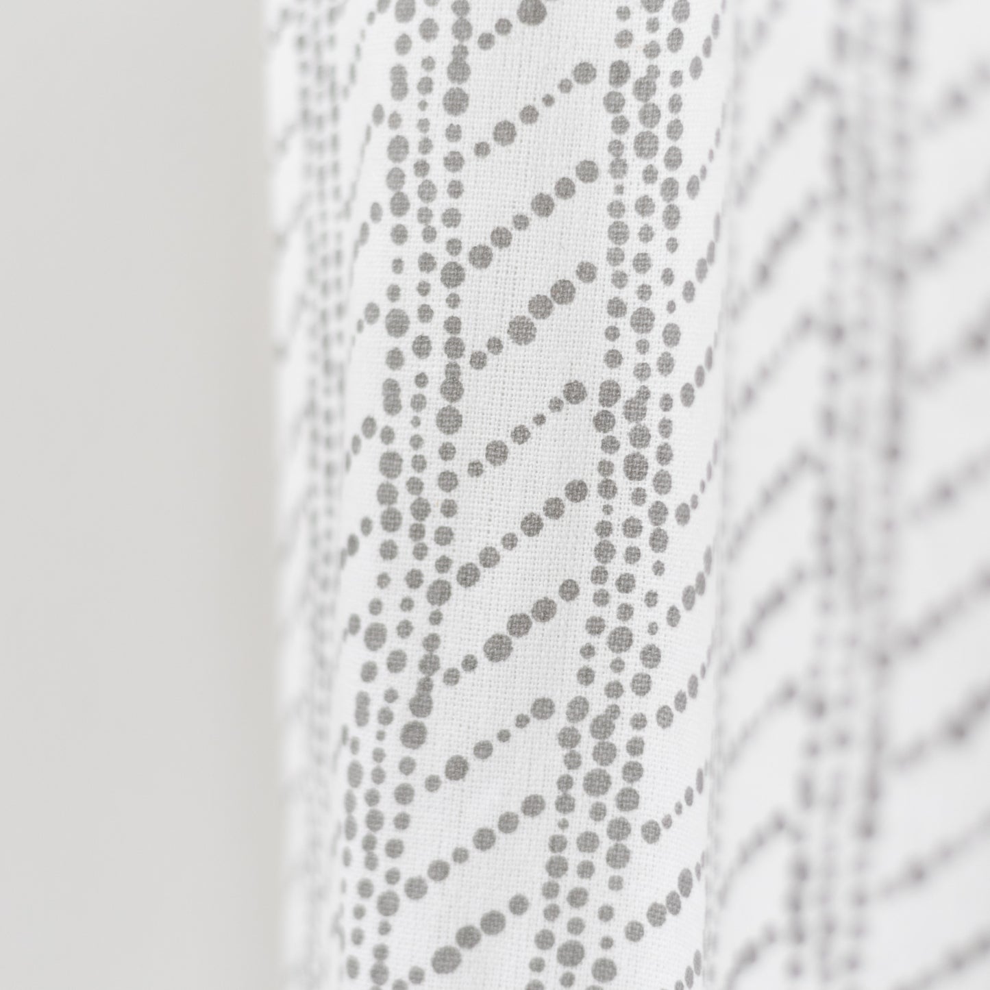 White curtain panel with gray dotted diagonal stripe pattern and textured weave.
