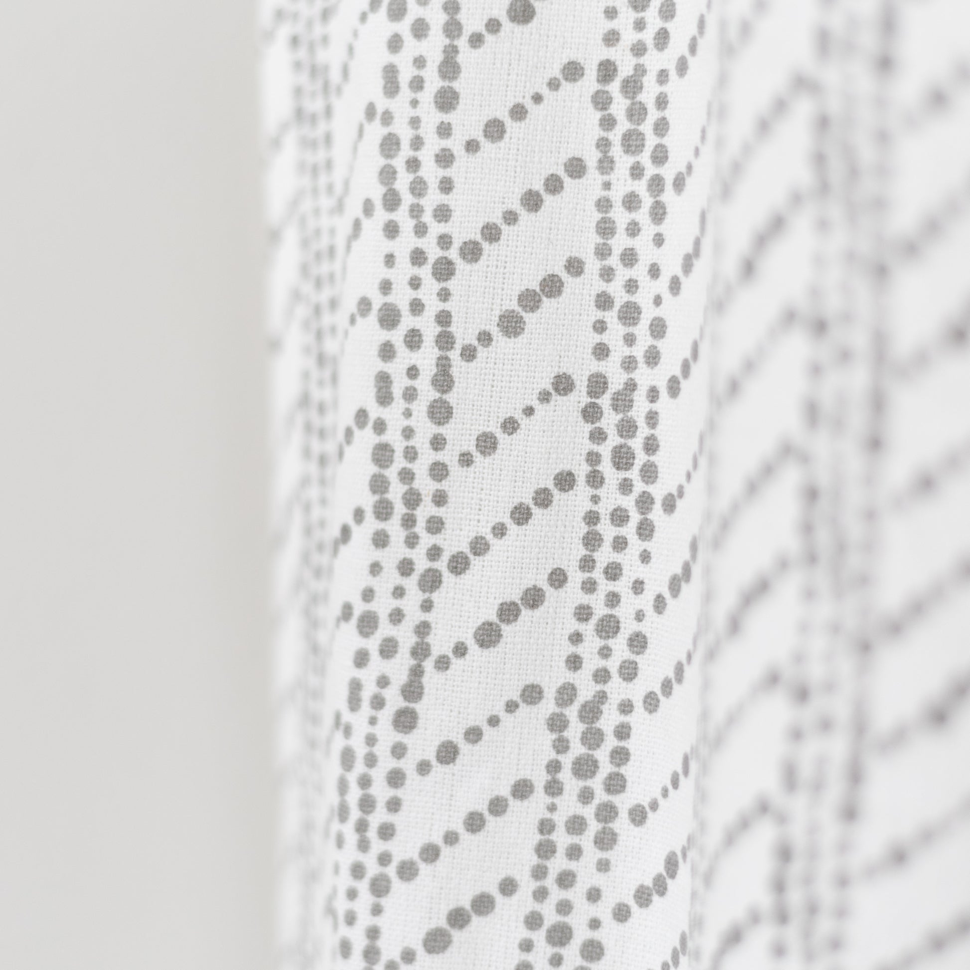 White curtain panel with gray dotted diagonal stripe pattern and textured weave.
