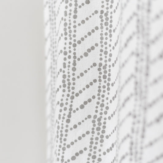 White curtain panel with gray dotted diagonal stripe pattern and textured weave.