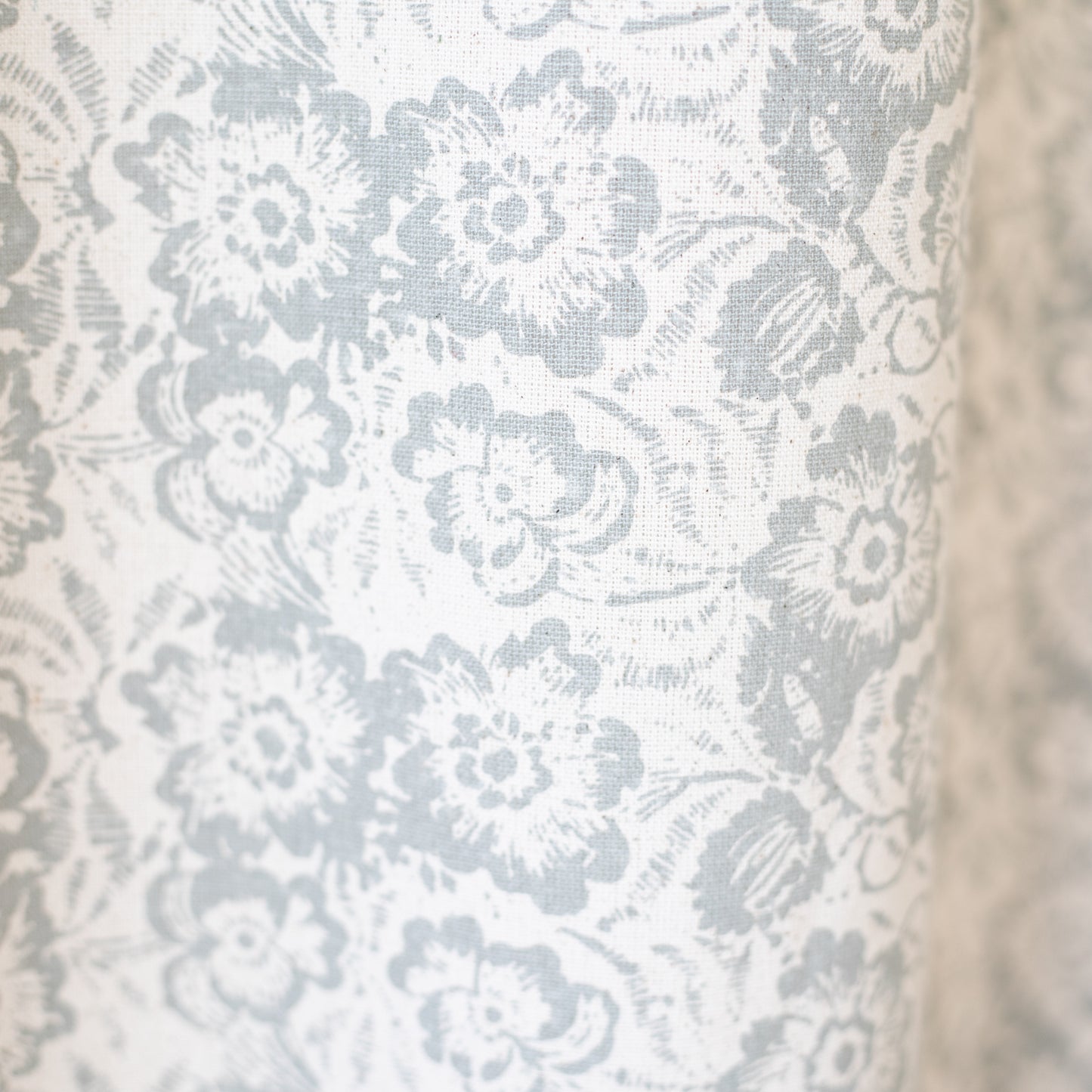 White and gray floral patterned curtain panel with textured fabric weave.