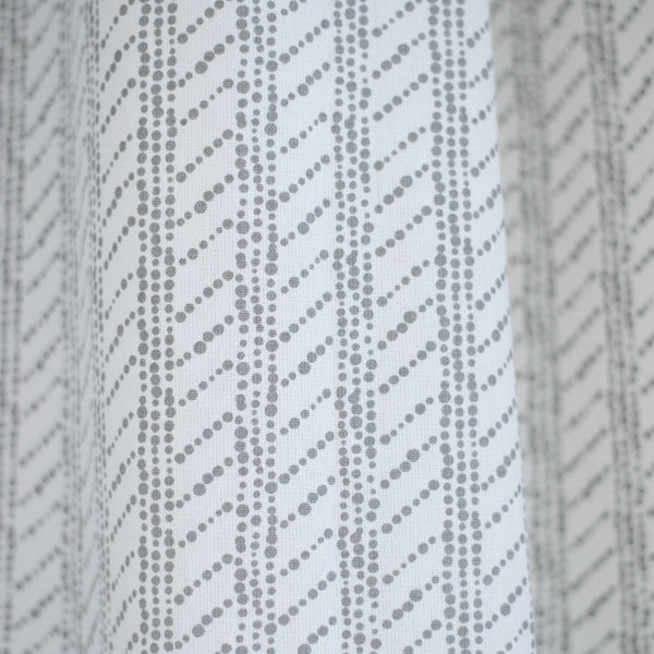 White shower curtain with gray diagonal dotted stripe pattern.