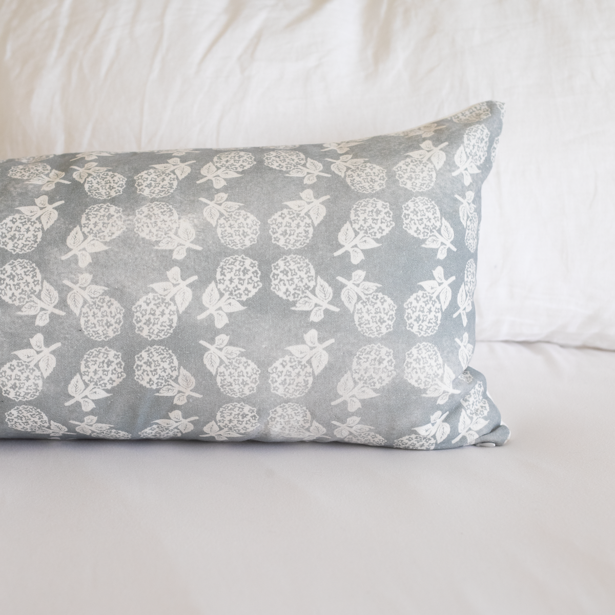 Gray rectangular pillow with cream floral pattern featuring pineapples and leafy stems.