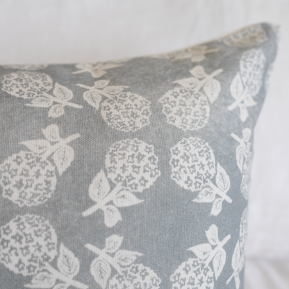 Gray linen pillow with white textured fruit and leaf pattern.