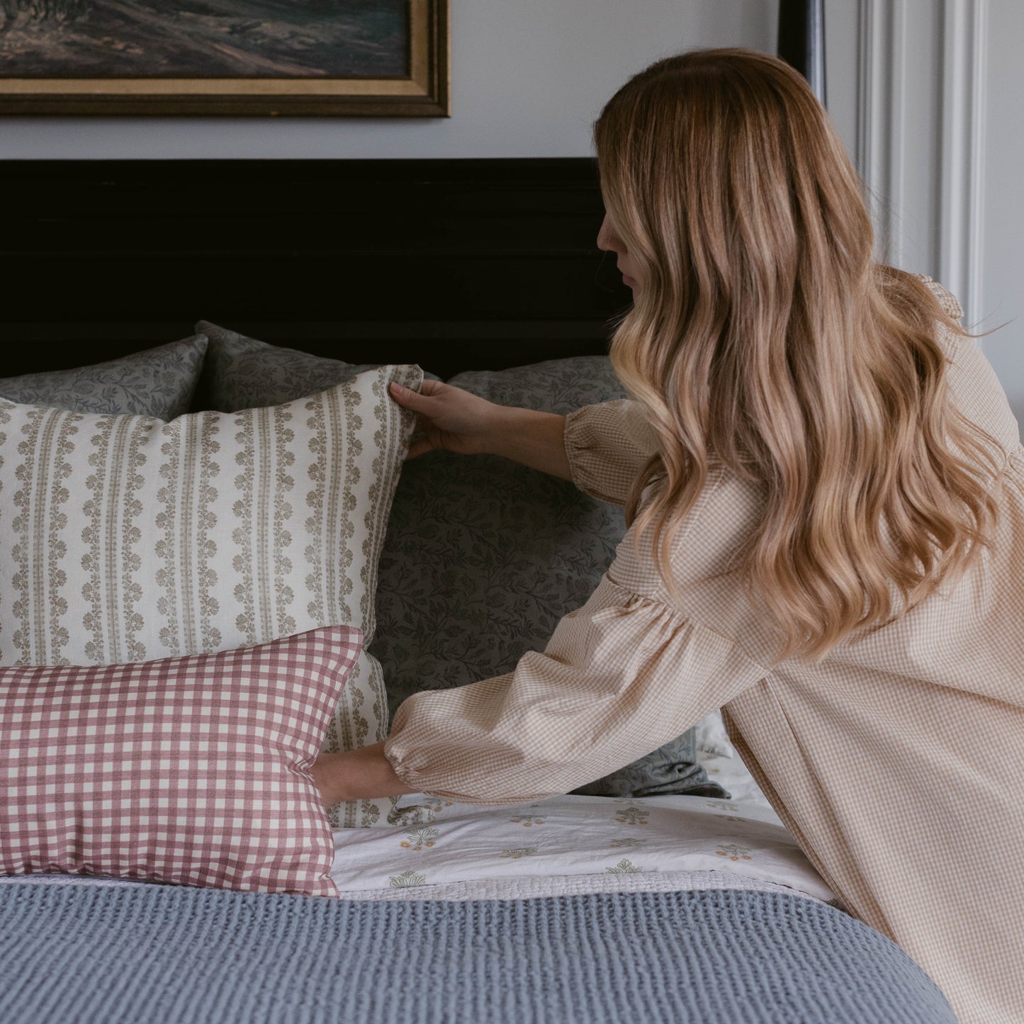 Double-sided linen pillow with floral pattern on one side and pink gingham check on the other.