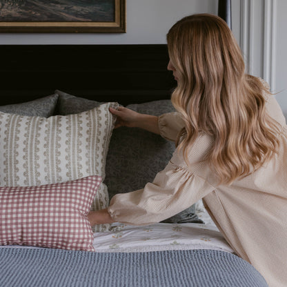 Double-sided linen pillow with floral pattern on one side and pink gingham check on the other.