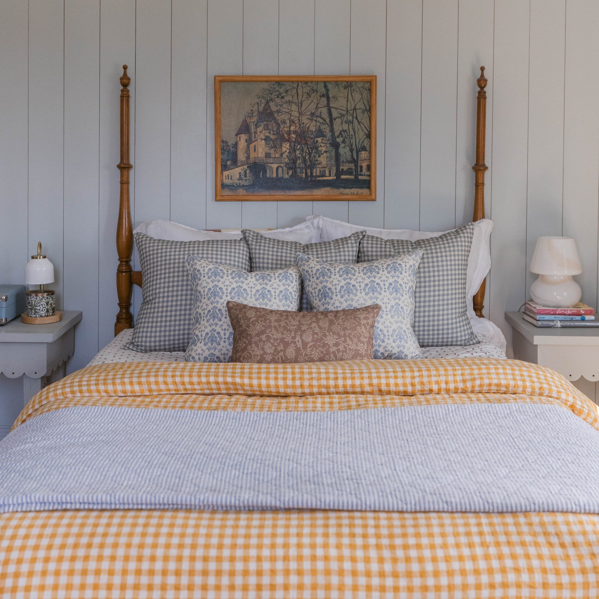 Dusty blue and white gingham check pillow displayed on bed with matching bedding.