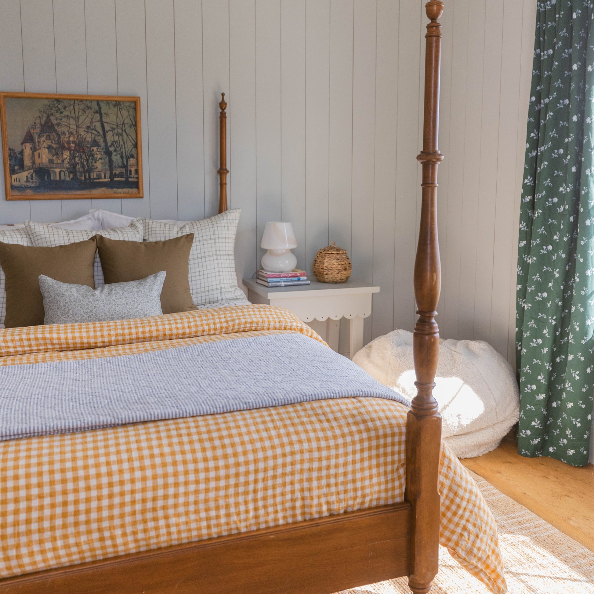 Wooden four-poster bed with turned finials and tall posts in a bedroom setting.
