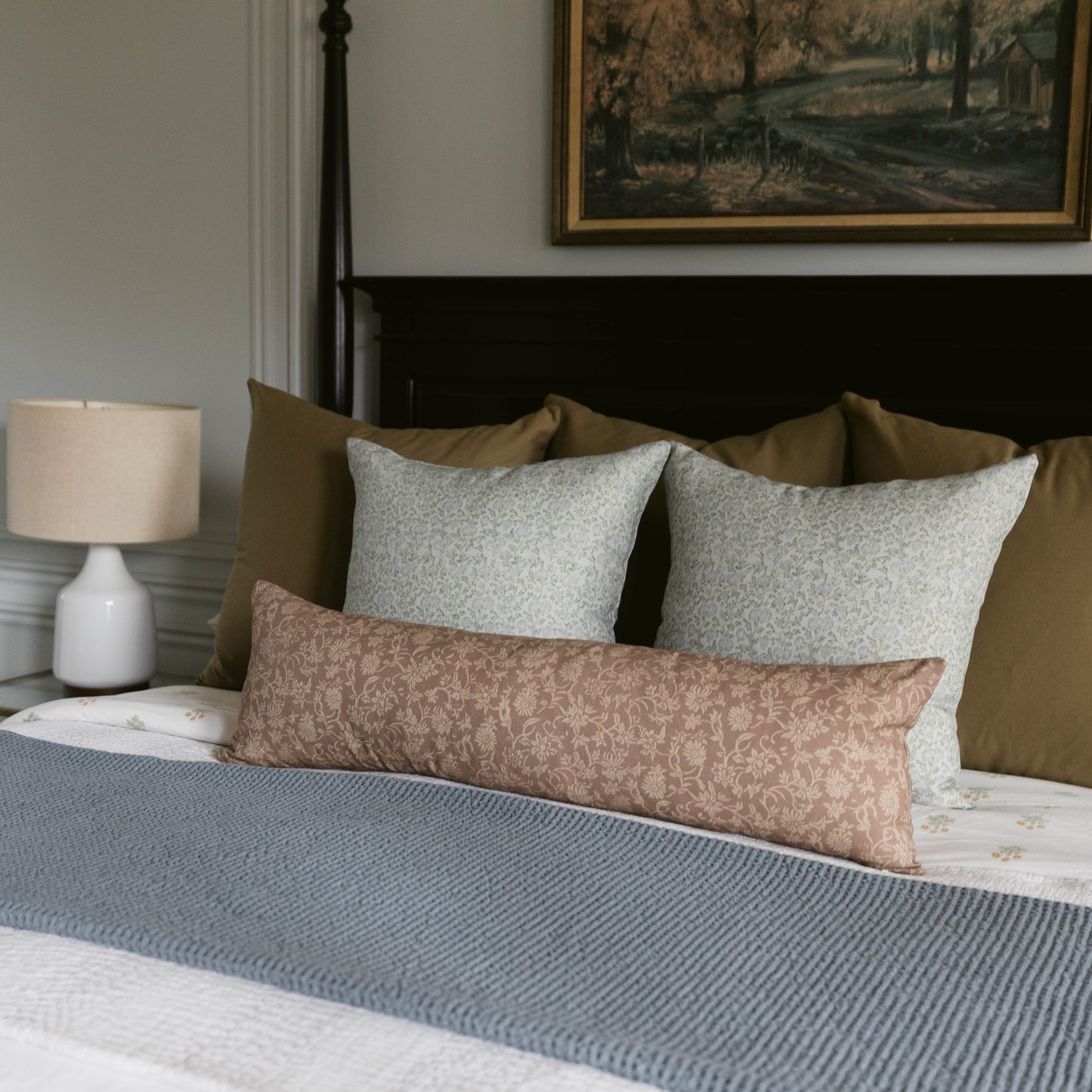 Leighton linen pillow in taupe with subtle damask pattern displayed on bed with coordinating pillows.