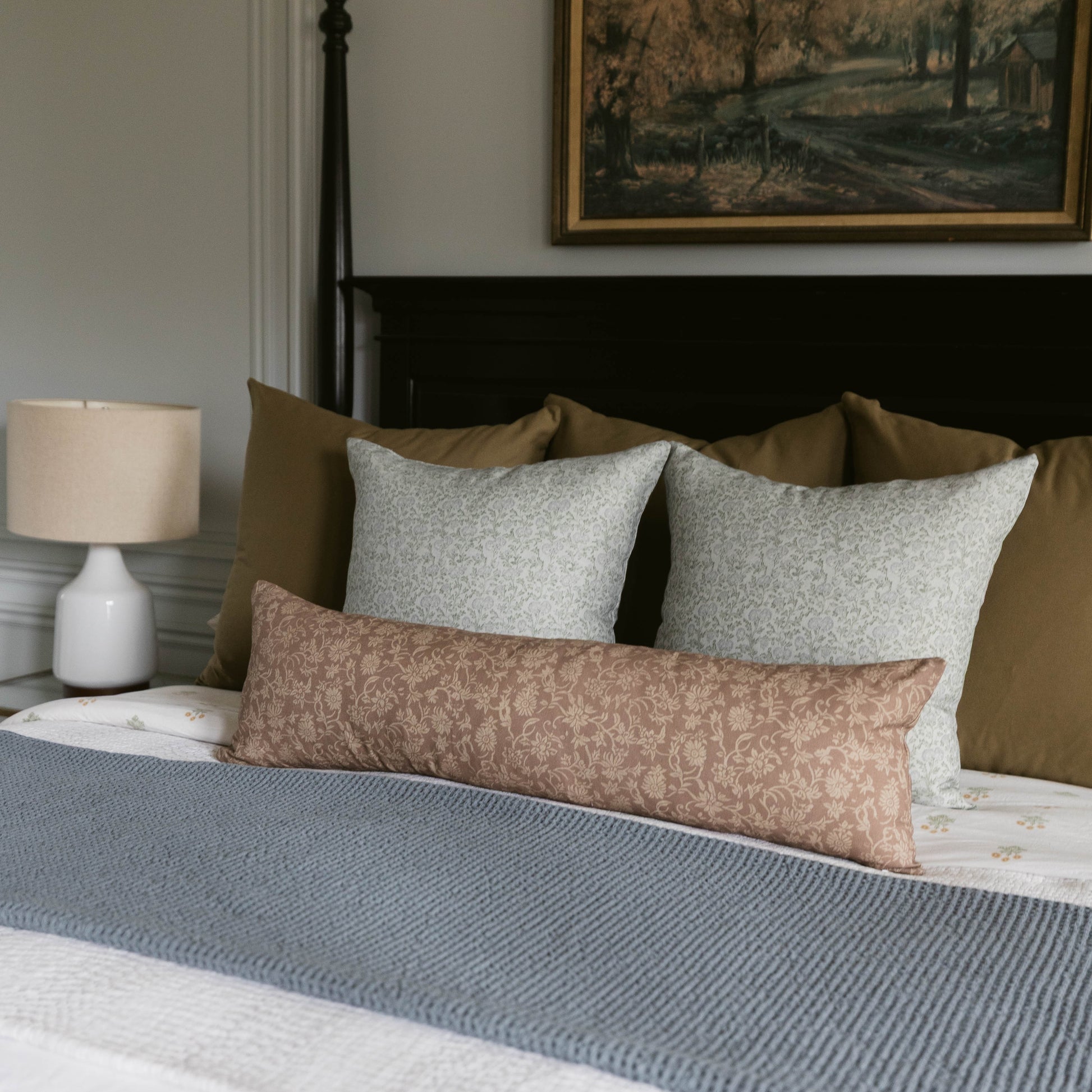 Leighton linen pillow in taupe with subtle damask pattern displayed on bed with coordinating pillows.