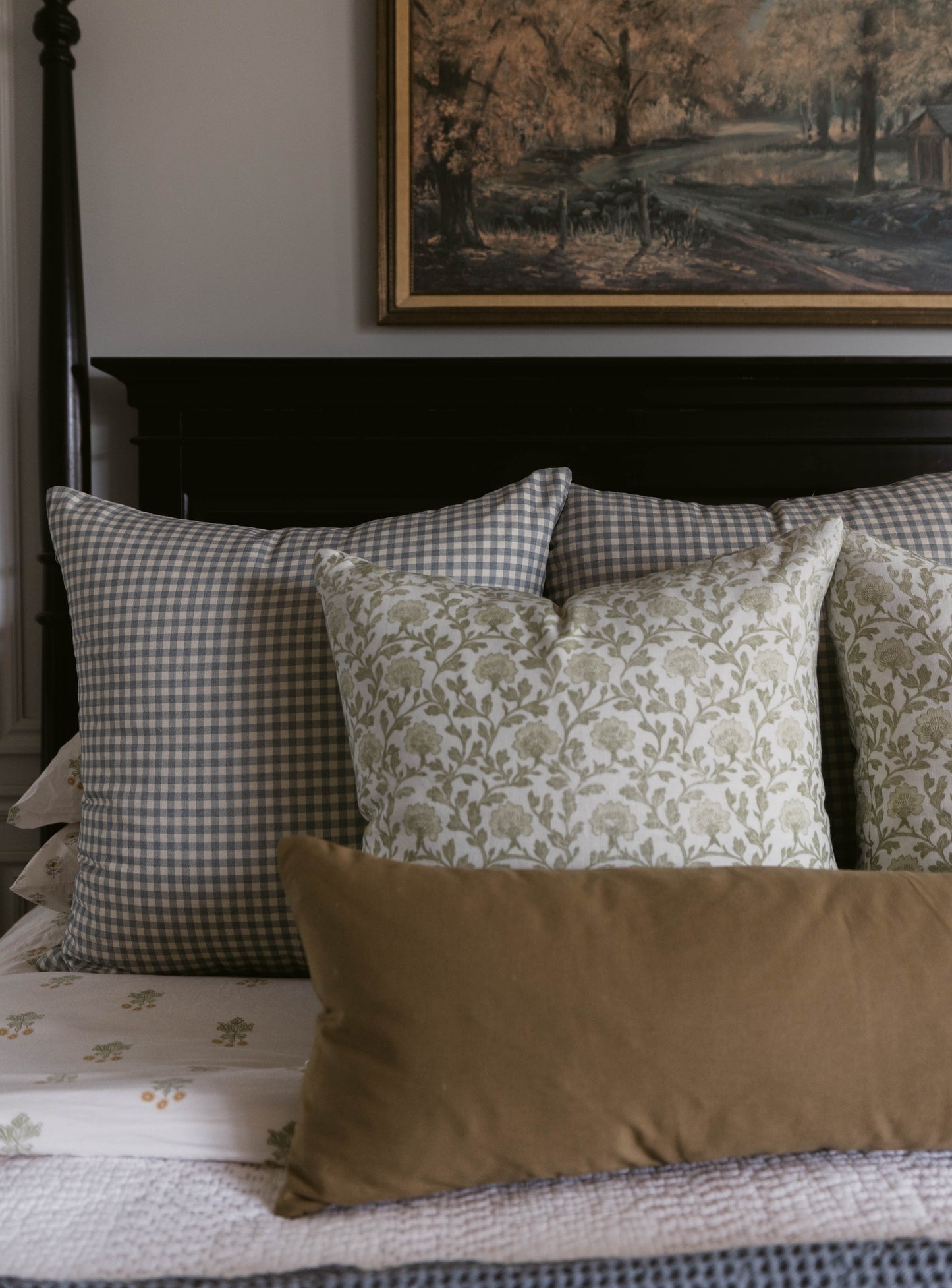 Gray and white gingham lumbar pillow displayed on bed with decorative pillows and headboard.