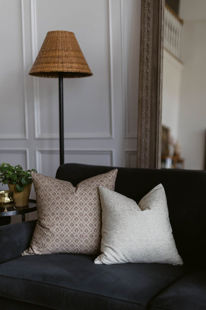 Woven wicker cone-shaped lamp shade in tan with black metal pole base.