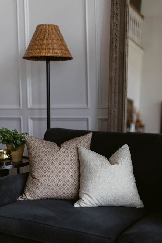 Woven wicker cone-shaped lamp shade in tan with black metal pole base.