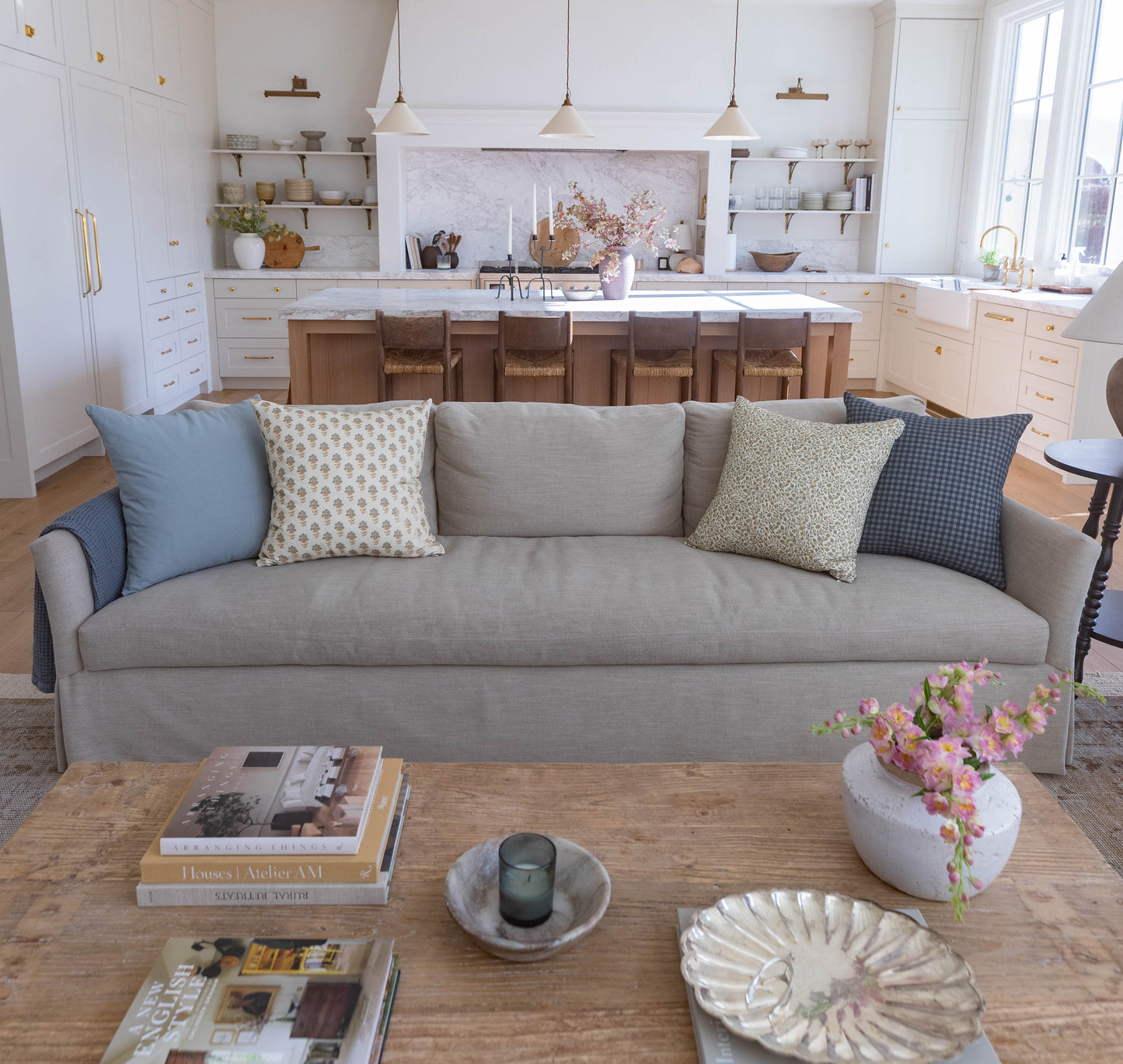 Navy gingham patterned throw pillow on gray sofa with coordinating solid and patterned accent pillows.