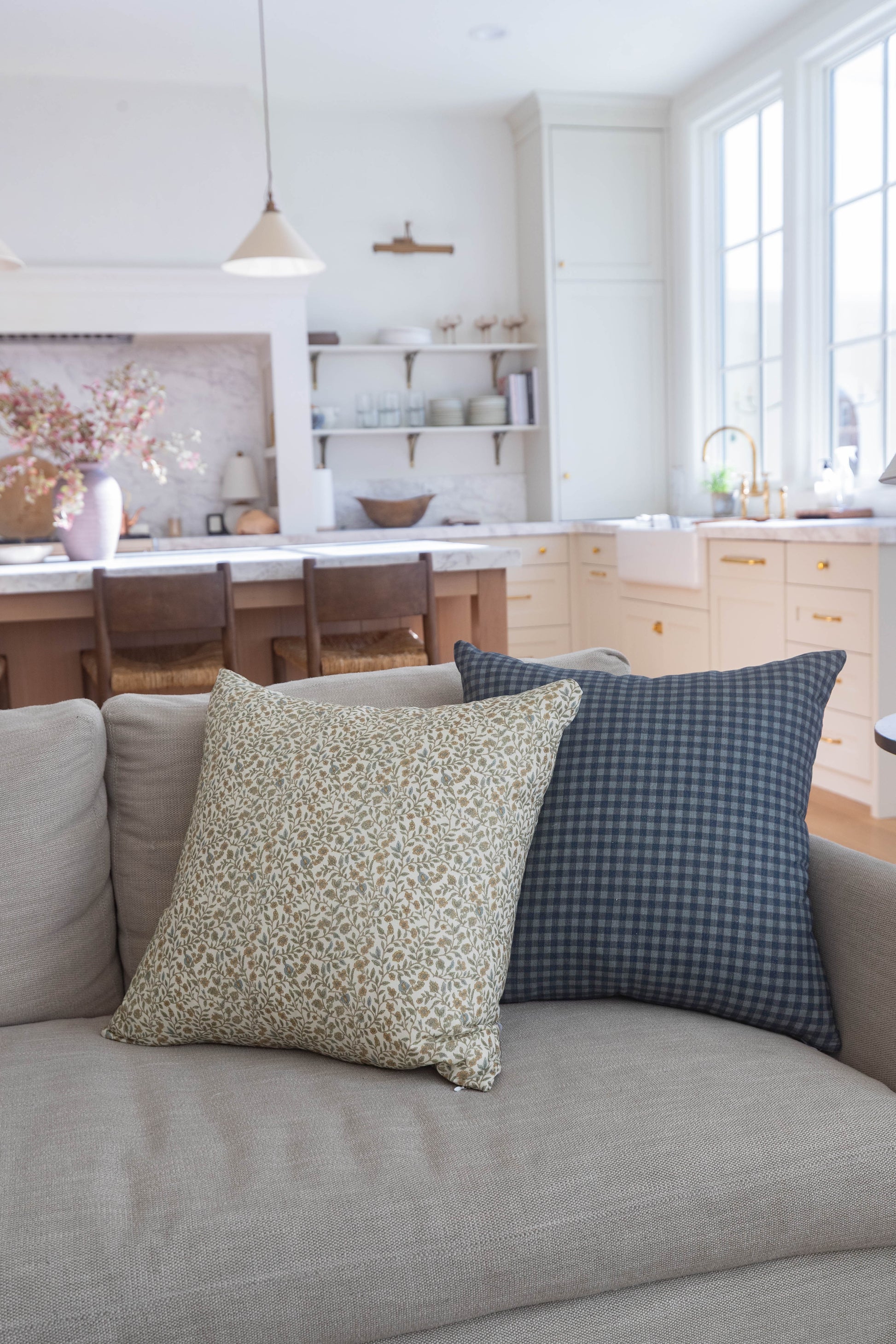 Navy gingham check pillow with small square pattern on gray sofa.