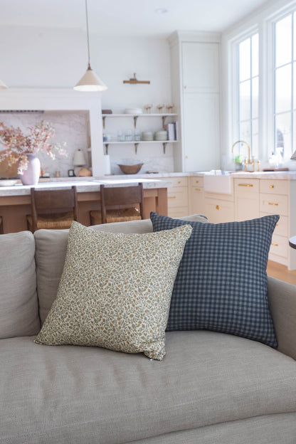 Navy gingham check pillow with small square pattern on gray sofa.
