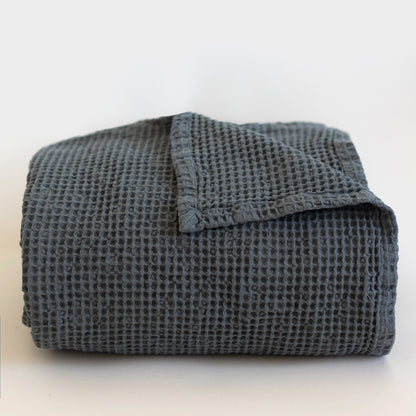 Storm blue waffle-textured blanket folded with one corner folded over the top.
