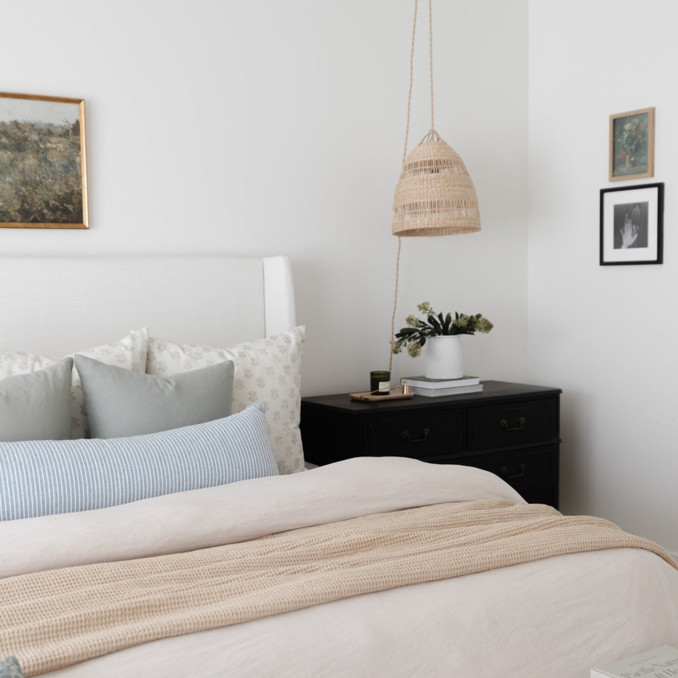 Woven pendant light in natural tan finish hanging above bedroom nightstand.