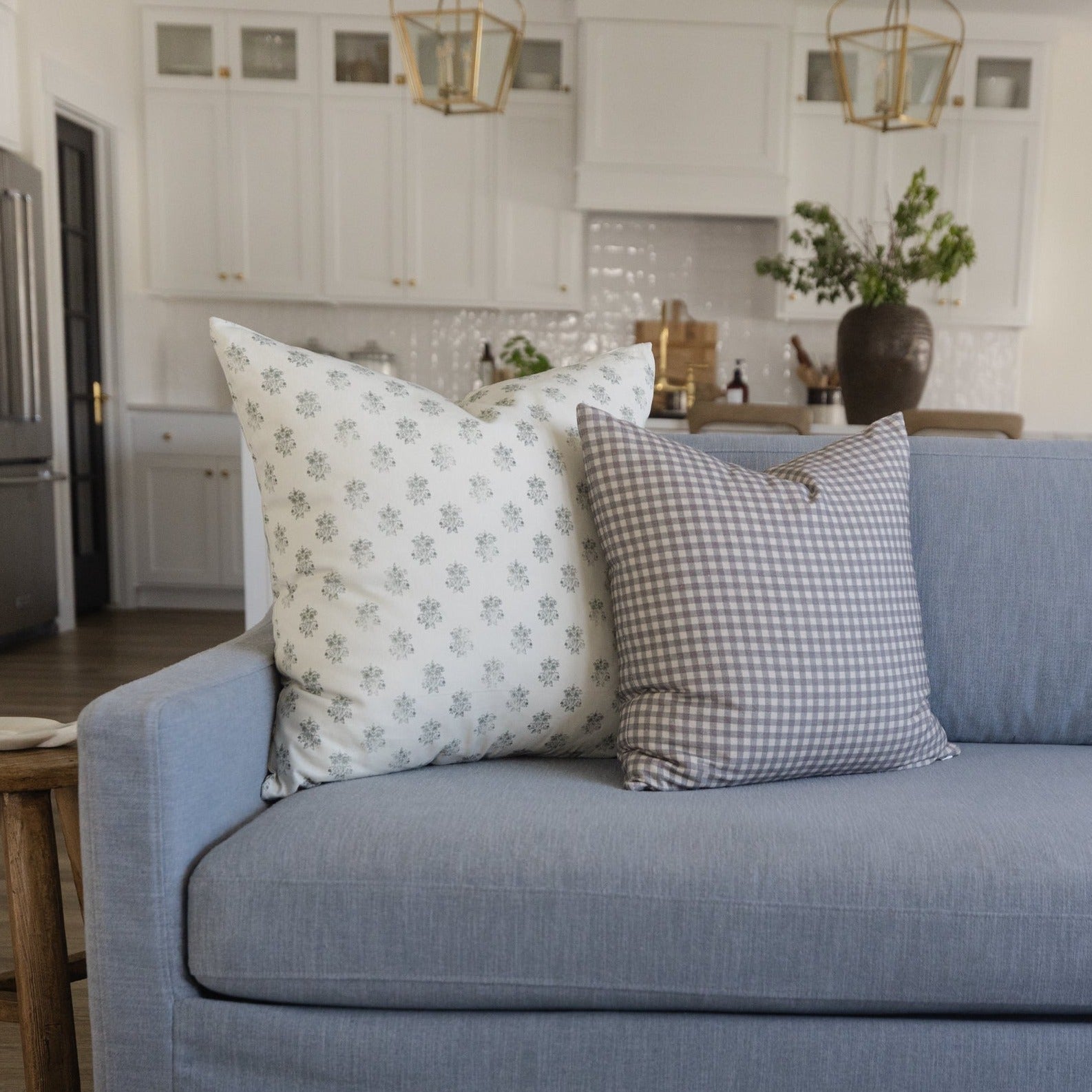 Light blue upholstered sofa with decorative throw pillows in a kitchen and living room setting.