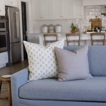 Blue upholstered sofa with decorative pillows in a kitchen-dining room setting.