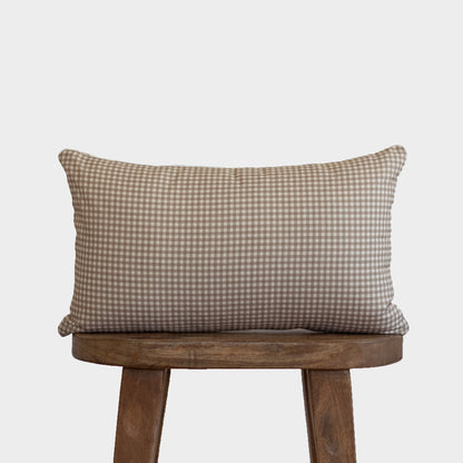 Tan and white mini gingham lumbar pillow displayed on a wooden chair.