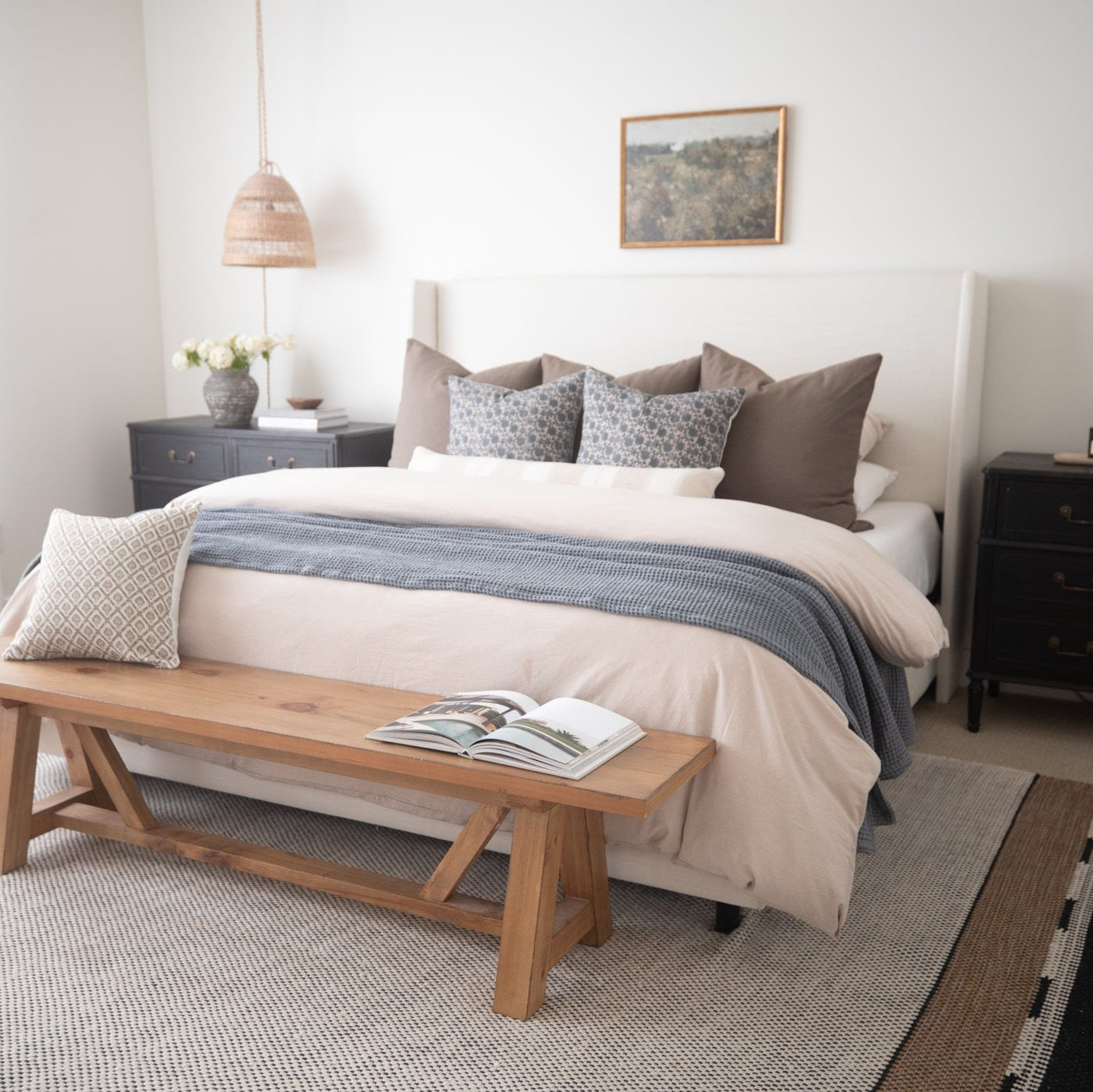 Beige king duvet cover set styled on bed with matching pillows and blue striped throw blanket.