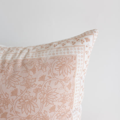 Beige and cream pillow with floral and geometric patterned fabric in contrasting tones.