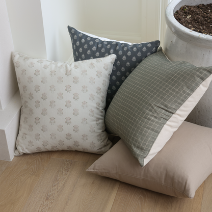 Four decorative pillows in varied patterns including floral, geometric, and solid designs in neutral tones.