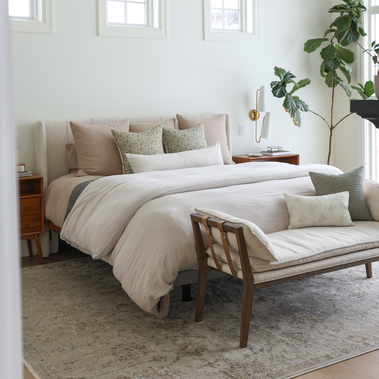 Tan bedding set displayed on bed with coordinating pillows in neutral bedroom setting.