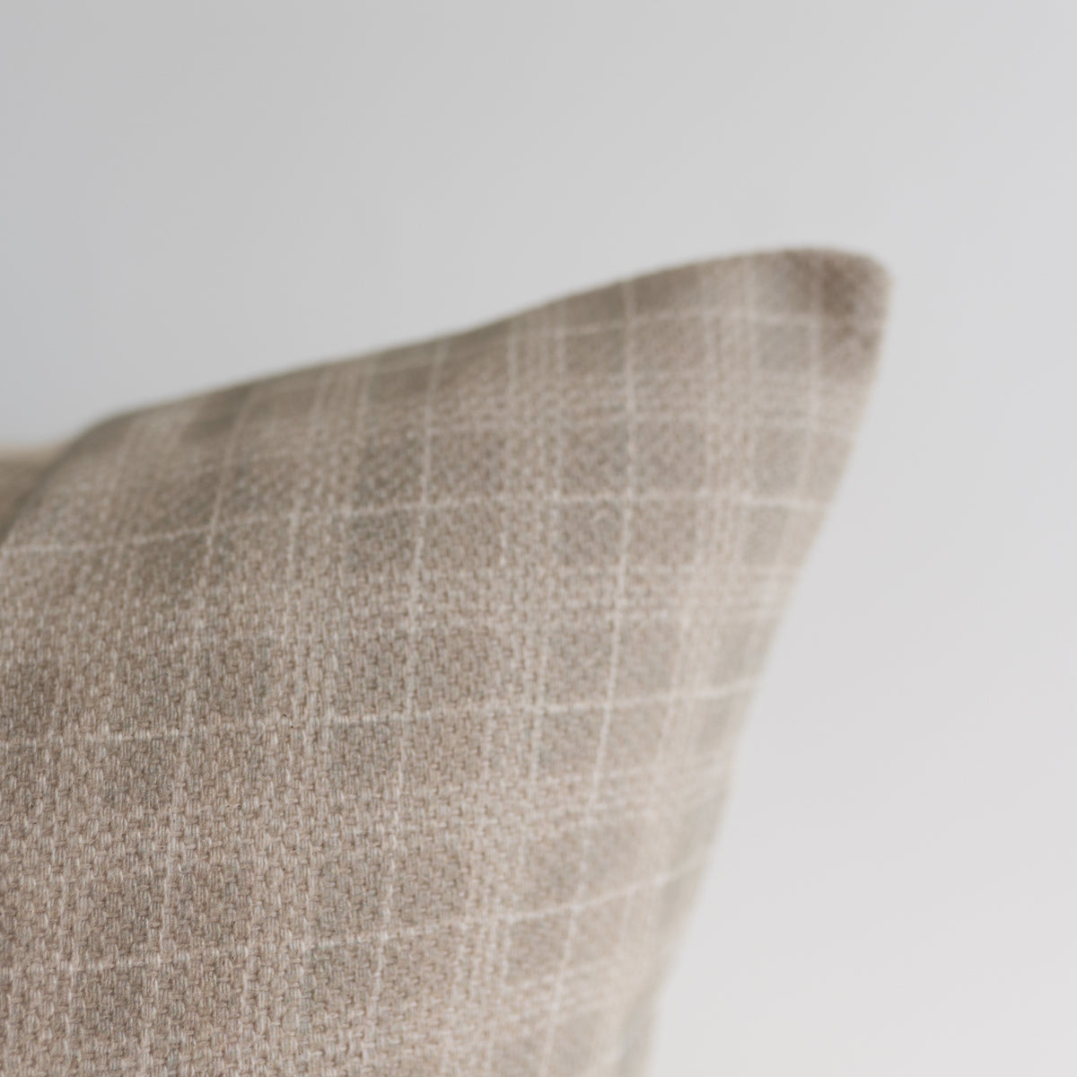 Taupe linen pillow cover with white window pane pattern visible on corner detail.