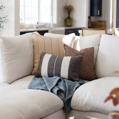 Storm blue waffle blanket draped over a cream-colored sofa with decorative pillows.