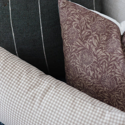 Colette pillow showing mauve floral pattern, black textured fabric, and white gingham check detail in layered arrangement.