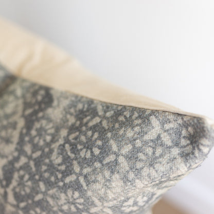 Gray and cream diamond floral patterned fabric with thick weave texture, folded corner detail visible.