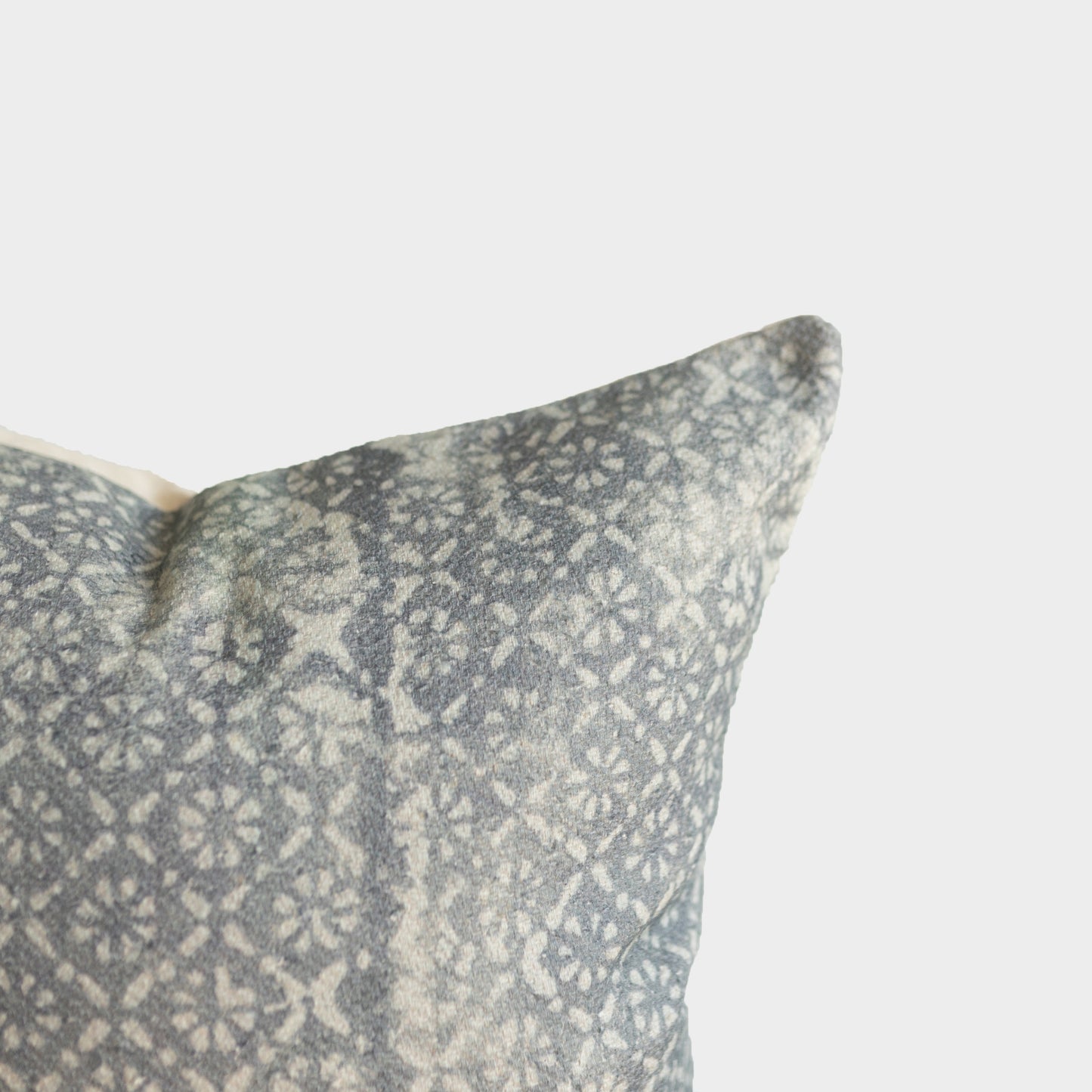Gray and cream woven pillow cover with diamond floral pattern and thick textile weave.